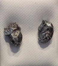 A pair of earrings made from meteorite fragments